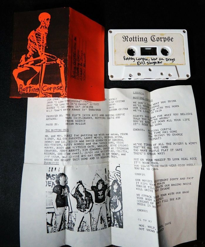 Rotting Corpse's 1986 demo cassette next to its orange skeleton cover and an unfolded insert with lyrics, credits, a thank-you list and a black-and-white band photo