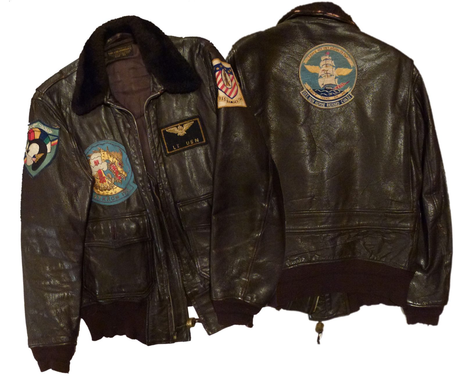 Front and back of a dark brown leather US Navy flight jacket with a fur collar, covered in sewn squadron and aircraft carrier patches, including USS Ranger on the sleeve and a large USS Bon Homme Richard patch on the back