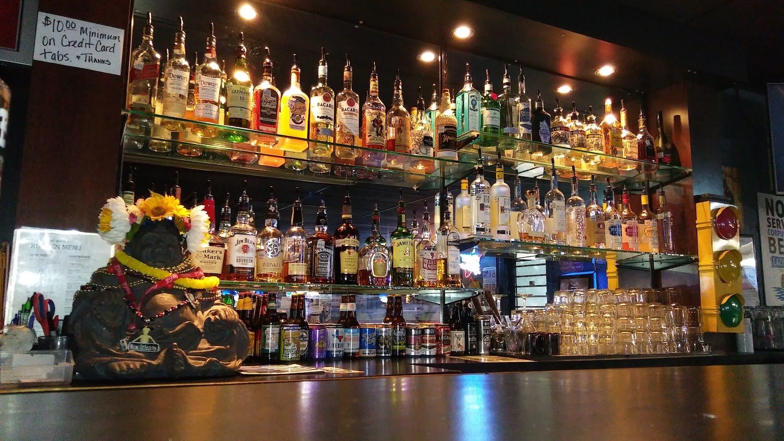Inside Black Monk Tavern in Corpus Christi, the back bar lined with bottles under warm lights