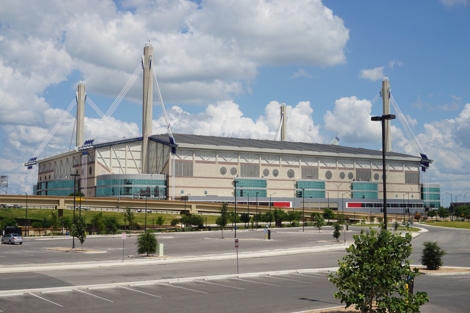 Exterior of the Alamodome in San Antonio, its curved white roof and support cables against the sky