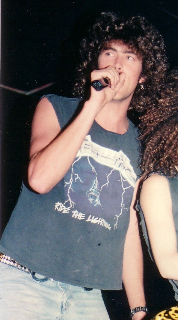 Jim "Moe" Mulqueen singing into the microphone onstage